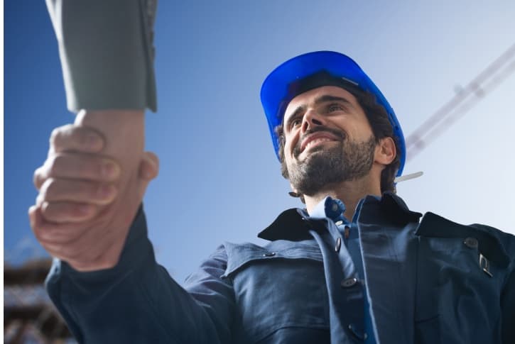 Corretor de sucesso apertando as mãos em um canteiro de obras