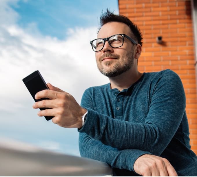 Homem consultando materiais do empreendimento pelo celular